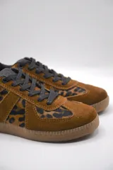 Zapatillas urbanas de cuero color crema con puntera y talón en gamuza gris, suela de goma marrón y cordones grises.