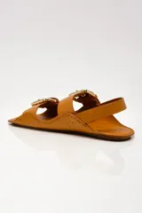 Sandalias negras de cuero con dos tiras anchas sobre el empeine, hebillas doradas y tira trasera.