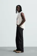 Musculosa blanca con efecto lavado, cuello redondo y sisa ancha. Estampado frontal con la leyenda "L.A. Legend Trailblazer" y un águila.