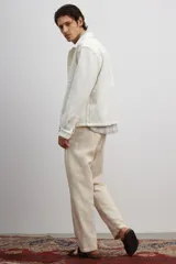 Sobrecamisa color crema en tejido texturizado de algodón, corte estándar, con cuello inglés, tapeta lisa, bolsillos superiores abiertos, canesú en la espalda, mangas largas con puños abotonados y bajo recto.