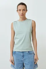 Musculosa roja de algodón con cuello redondo y botones decorativos en los hombros.