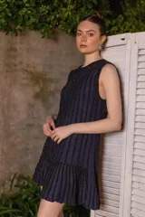 Vestido corto azul marino con lurex, corte recto, sin mangas y volado en el ruedo.