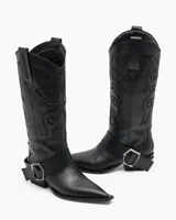 Bota texana de cuero negro con bordados en el caño, punta fina y correa con hebilla metálica.
