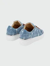 Zapatillas bajas de denim celeste con estampado de monograma y apliques de strass.