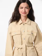 Chaqueta de algodón color arena, con cuello extendido, cierre con botones y cinturón para atar en la cintura.