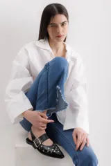 Zapato chata negro de cuero con punta fina y correa con hebilla metálica.