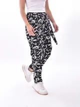 Pantalón babucha negro con estampado de hojas blancas y lazo en la cintura.