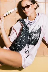 Bolso de nylon negro con estampado de lunares blancos, diseño plisado y cierre superior.