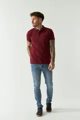 Remera polo negra de manga corta con cuello clásico, cierre de botones, bolsillo en el pecho y logo estampado.