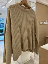 Sweater color beige con cuello redondo y diseño de trenzas en relieve.