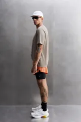 Camiseta deportiva color beige confeccionada en tejido con estructura, ligero y elástico en todas direcciones. Tiene cuello redondo, manga corta, costuras planas y logo estampado en el bajo.