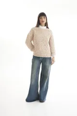 Sweater de punto calado color crema, con cuello alto y mangas largas.