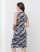 Vestido tejido sin mangas, con estampado floral en tonos azul, gris y blanco. Tiene cuello redondo y abertura central en la espalda con cierre invisible.