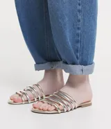 Sandalia plana tipo mule con tiras acolchadas en tonos dorado y plateado alternados, puntera cuadrada y suela plana.