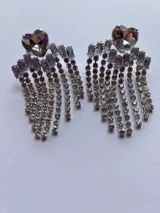 Par de aros colgantes con forma de corazón de cristal y flecos de strass plateados.