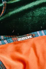 Conjunto de bikini negro con estampado difuminado en blanco y negro en los bordes y tiras. El corpiño es bandeau con detalle de flor negra en el centro.