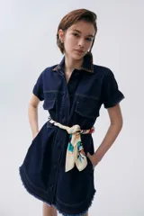 Vestido corto de denim color azul, con mangas cortas, botones en el frente y bolsillos laterales.