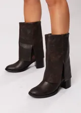 Bota de cuero marrón con caña volcada, horma redonda y taco cuadrado.