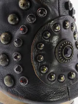 Bota corta de cuero bovino, estilo motociclista o biker, con efecto desgastado en tonos negro y gris. Presenta caña arrugada y detalles de tachas redondas en la parte trasera del tobillo. Cierre con cremallera lateral.