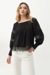 Blusa negra con escote cuadrado, mangas largas abullonadas con detalles de encaje y galón de encaje en el ruedo.