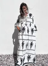 Vestido túnica largo de algodón color blanco con estampado de flores abstractas en negro, escote en V y mangas 3/4 amplias.