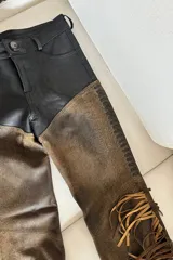 Pantalón texano de cuero ovino vintage marrón y negro con flecos.