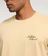 Remera color arena de corte recto, con cuello redondo y mangas cortas. Presenta un pequeño estampado con letras en el lado izquierdo del pecho.