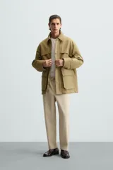 Pantalón verde militar de corte carrot fit, confeccionado en tejido de algodón. Cuenta con cintura elástica ajustable con cordón, bolsillos frontales y un bolsillo trasero de plastrón.