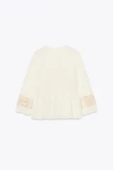 Blusa rústica color crema de cuello redondo con cordón, escote pico y manga larga acabada en elástico. Detalle de tejido combinado en crochet en mangas y parte superior del frente.