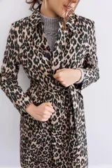 Trench de gabardina con estampado animal print, diseño sastrero, botones al frente y lazo en la cintura para ajuste.