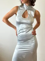 Vestido largo ajustado de lycra color negro, con cuello mao, escote tipo gota y abertura lateral en la falda.