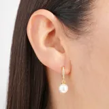 Aros colgantes dorados con forma de argolla con pequeños brillantes y dije de perla blanca.