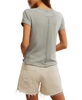 Remera blanca con cuello redondo y estampado frontal con la palabra 'SURF' en color coral.
