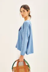 Sweater celeste de viscosa, poliéster y poliamida, de corte holgado y manga larga. Tiene bordado en buclé con la palabra 'Amour' en el frente.