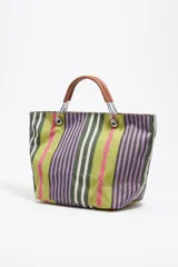 Bolso tote de tela a rayas verticales en tonos verde oliva, lila, blanco y rosa. Tiene doble asa de mano de cuero marrón y logo de la marca en etiqueta de cuero.