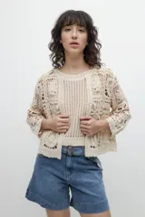 Chaqueta corta color beige, tejida a crochet con diseño floral.