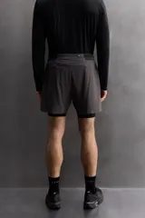 Shorts deportivos color beige con cintura elástica negra, bolsillos laterales y logo estampado en la pierna.