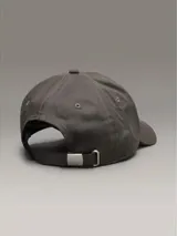 Gorra gris de algodón con visera curva y logo de Calvin Klein Jeans bordado en el frente. Ajuste trasero con hebilla metálica.