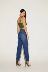 Pantalón de jean azul con corte recto y aplique bordado en verde en el muslo.