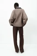Chaqueta de punto color marrón claro con cuello solapa a contraste en simil cuero color marrón oscuro y manga larga. Cierre frontal con cremallera metálica.