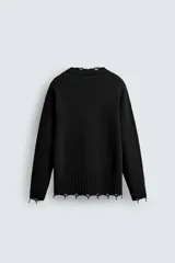 Sweater negro de punto con cuello redondo y mangas largas. Tiene un corte holgado y terminaciones irregulares con efecto desgastado en cuello, puños y ruedo.