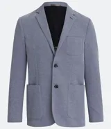 Blazer masculino color gris claro, de tejido liso con textura casual, con solapas, bolsillos amplios de parche en la parte delantera y un bolsillo superior. Cierre frontal de un solo botón.