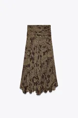 Falda midi de tiro alto con estampado paisley en tonos marrones y dorados. Presenta cintura con drapeado lateral y bajo asimétrico evasé. Cierre con cremallera oculta en la costura.