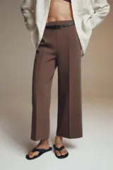 Pantalón culotte color verde oliva, de tiro medio y pierna ancha. Incluye cinturón ajustable con hebilla metálica y cierre lateral con cremallera oculta.