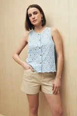 Musculosa negra con bordado calado y cierre frontal con botones.