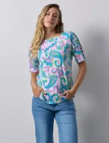 Remera estampada con diseño paisley en tonos celeste, rosa, amarillo y verde. Tiene mangas cortas con detalle de aberturas y lazos en los hombros.