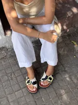Sandalias con estampado de vaca, con hebilla dorada y suela marrón.