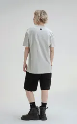 Remera gris de manga corta, cuello redondo y calce regular con recorte en espalda, realizada en algodón premium muy suave al tacto.