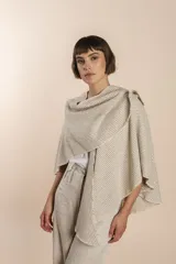 Ruana corta color crema con rayas horizontales finas en marrón claro y terminación de crochet.