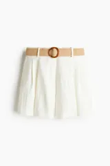 Short blanco de tiro alto con pinzas, bolsillos laterales y traseros. Incluye cinturón trenzado con hebilla redonda.